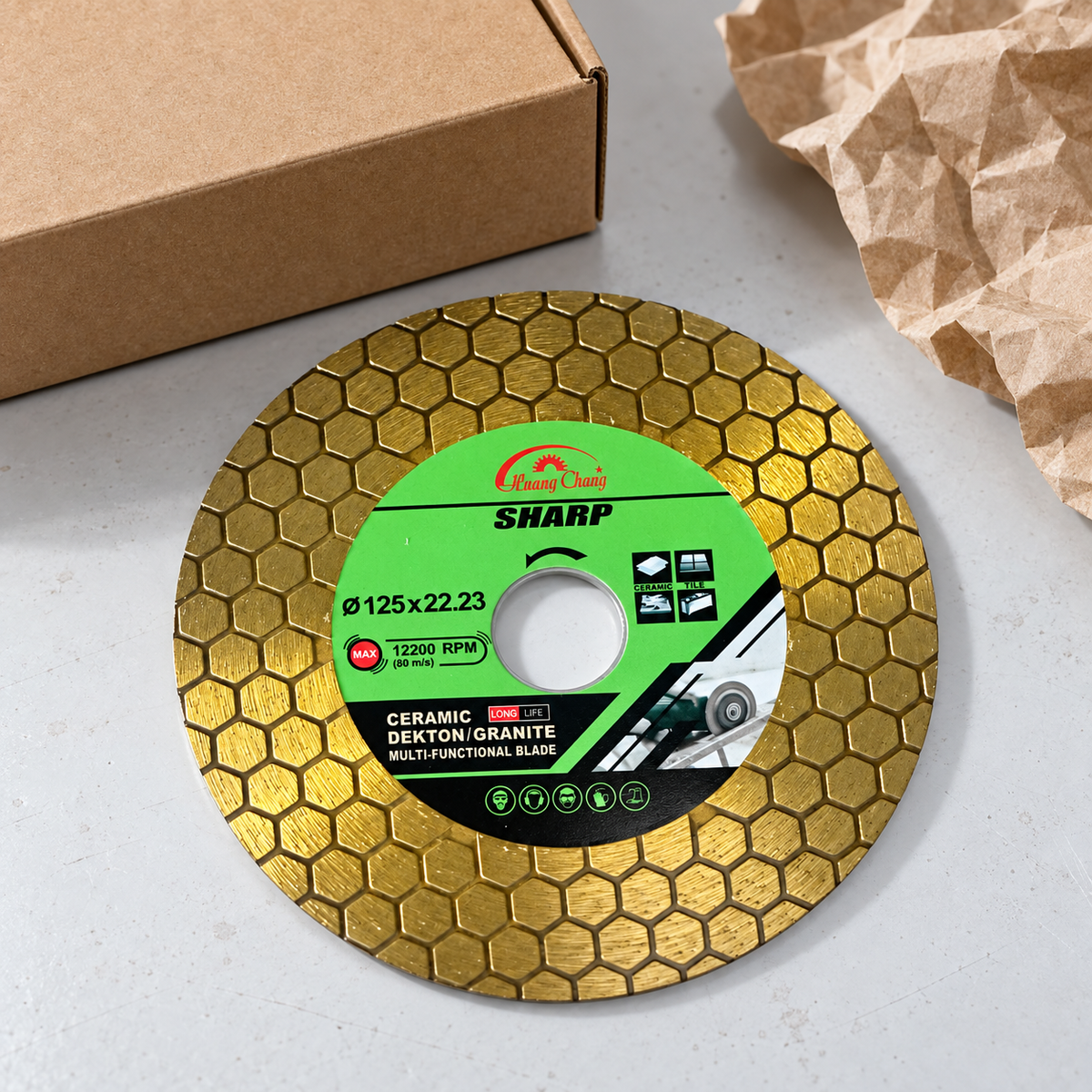 Pictured 125 mm gold disc beside a plain carton and packing paper