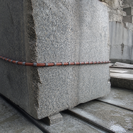 Rubber coated diamond wire saw cutting a granite quarry block